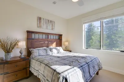 a bedroom with a bed with a wooden headboard and a window at Stunning Winter Park Condo Near Slopes! in Winter Park
