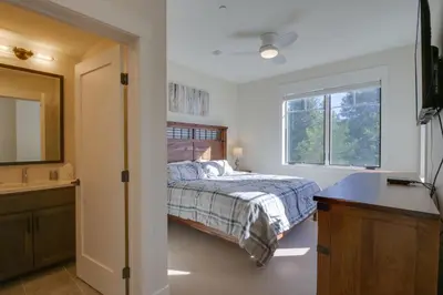 a bedroom with a bed and a sink and a mirror at Stunning Winter Park Condo Near Slopes! in Winter Park