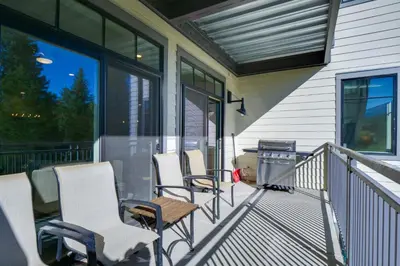 a porch with chairs and a grill on a house at Stunning Winter Park Condo Near Slopes! in Winter Park
