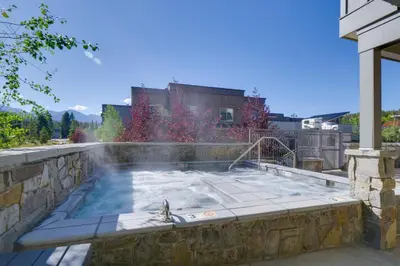 a hot tub in a stone wall with a fountain at Stunning Winter Park Condo Near Slopes! in Winter Park