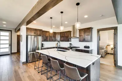 an open kitchen with a large island with bar stools at Ski-InandOut Home with Hot Tub in Granby Ranch Resort! in Granby