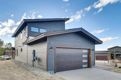 a gray garage with a brown garage door at Ski-InandOut Home with Hot Tub in Granby Ranch Resort! in Granby