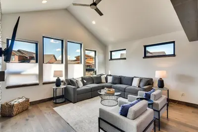 a living room with a couch and chairs and windows at Ski-InandOut Home with Hot Tub in Granby Ranch Resort! in Granby