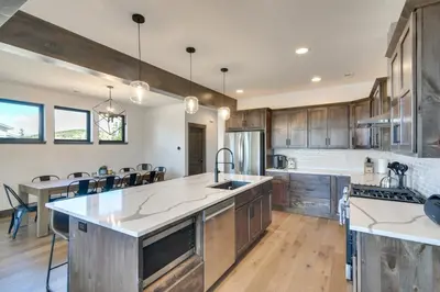 an open kitchen with wooden cabinets and a dining room at Ski-InandOut Home with Hot Tub in Granby Ranch Resort! in Granby