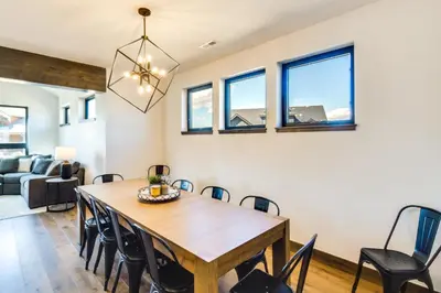 a dining room and living room with a wooden table and chairs at Ski-InandOut Home with Hot Tub in Granby Ranch Resort! in Granby