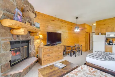 a living room with a fireplace and a tv at 2 Mi to Granby Ranch Mtn Condo with Hot Tub! in Granby