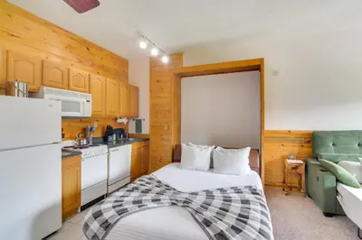 a small kitchen with a bed and a refrigerator at 2 Mi to Granby Ranch Mtn Condo with Hot Tub! in Granby