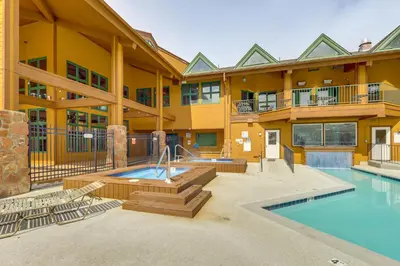 a large building with a swimming pool and a house at 2 Mi to Granby Ranch Mtn Condo with Hot Tub! in Granby