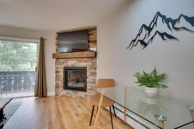 a living room with a table and a fireplace at Estes Park Vacation Rental 1 Mi to National Park in Estes Park