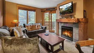 a living room with a fireplace and a tv at Ski in Ski out 1 BDR at River Run Village in Keystone
