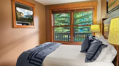 a bedroom with a bed and a large window at Ski in Ski out 1 BDR at River Run Village in Keystone