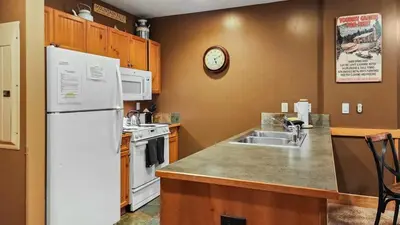 a kitchen with a white refrigerator and a sink at Ski in Ski out 1 BDR at River Run Village in Keystone