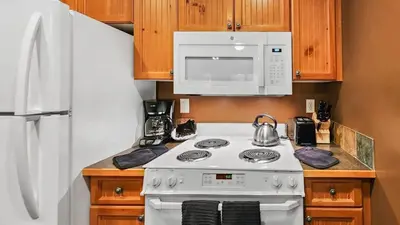 a kitchen with a white stove and a microwave at Ski in Ski out 1 BDR at River Run Village in Keystone