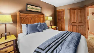 a bedroom with a bed and two lamps and a door at Ski in Ski out 1 BDR at River Run Village in Keystone
