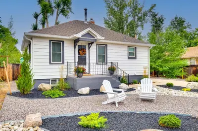 a house with two white chairs in a yard at Loveland Retreat with Bicycles, Deck and Fire Pit! in Loveland
