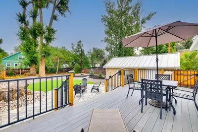 a deck with a table and an umbrella at Loveland Retreat with Bicycles, Deck and Fire Pit! in Loveland