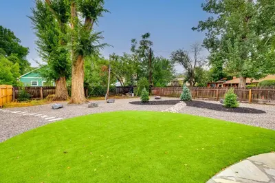 a yard with a green lawn and a fence at Loveland Retreat with Bicycles, Deck and Fire Pit! in Loveland