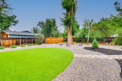 a yard with a green lawn and a tree at Loveland Retreat with Bicycles, Deck and Fire Pit! in Loveland