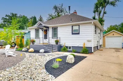 a small white house with a gravel yard at Loveland Retreat with Bicycles, Deck and Fire Pit! in Loveland