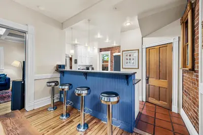 a kitchen with a blue counter and stools at 151 W 2nd Ave - Denver in Denver
