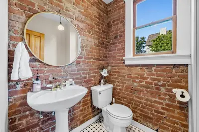 a brick bathroom with a sink and a mirror at 151 W 2nd Ave - Denver in Denver