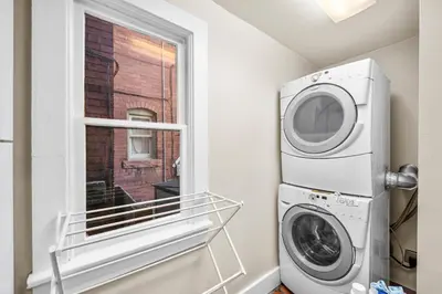 a laundry room with a washing machine and a window at 151 W 2nd Ave - Denver in Denver