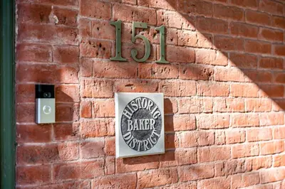 a sign on the side of a brick wall at 151 W 2nd Ave - Denver in Denver