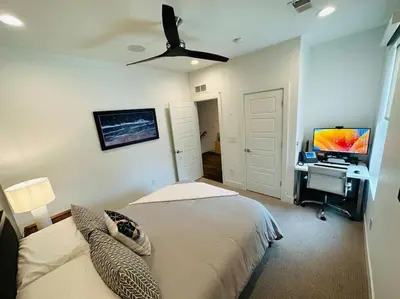 a bedroom with a bed and a desk with a television at Downtown Denver Smart House in Denver