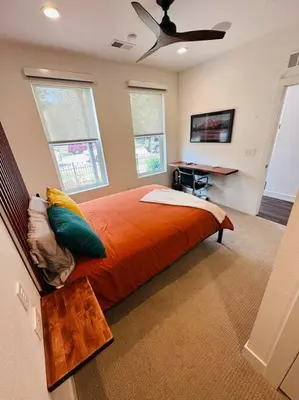a bedroom with a large orange bed and a desk at Downtown Denver Smart House in Denver