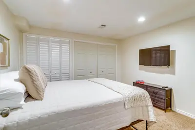 a bedroom with a white bed and a television at 9 Mi to Dtwn Denver Aurora Vacation Rental in Aurora