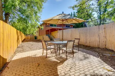 a patio with a table and chairs and an umbrella at 9 Mi to Dtwn Denver Aurora Vacation Rental in Aurora