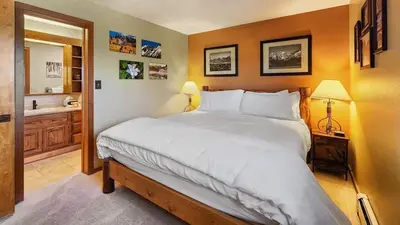 a bedroom with a large bed and a bathroom at Tranquil 2BR Near Trails and Free Shuttle in Silverthorne