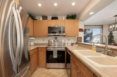 a kitchen with a stainless steel refrigerator and a sink at Snowblaze A24 condo in Winter Park