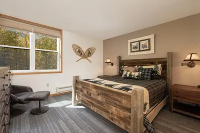 a bedroom with a wooden bed and a window at Snowblaze A24 condo in Winter Park