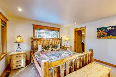 a bedroom with a wooden bed and a window at Moose Cabin in Grand Lake