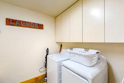 a laundry room with a washing machine and cabinets at Moose Cabin in Grand Lake