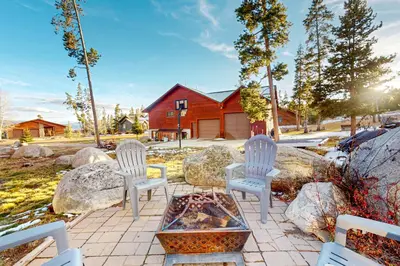 three white chairs and a fire pit in a yard at Moose Cabin in Grand Lake