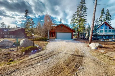 a house with a garage on a dirt road at Moose Cabin in Grand Lake