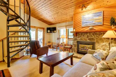 a living room with a staircase and a fireplace at Winter Park Condo with Sleeping Loft - Near Main St in Winter Park