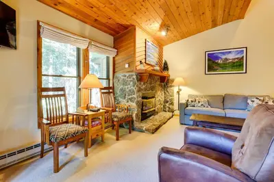 a living room with a couch and a fireplace at Winter Park Condo with Sleeping Loft - Near Main St in Winter Park
