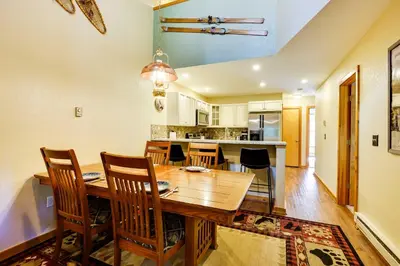 a kitchen and dining room with a wooden table and chairs at Winter Park Condo with Sleeping Loft - Near Main St in Winter Park