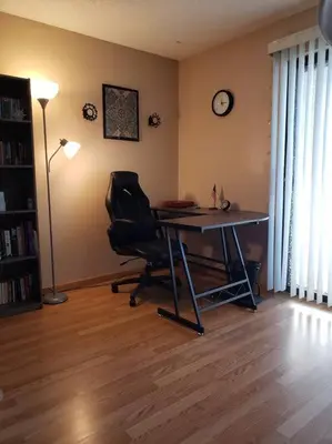 a room with a desk and a chair and a clock at Entire 1 BR Condo- Near Anschutz, UC Health, DIA- In-Unit Washer Dryer- Seasonal Discounts! in Aurora