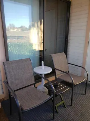 two chairs and a table on a porch at Entire 1 BR Condo- Near Anschutz, UC Health, DIA- In-Unit Washer Dryer- Seasonal Discounts! in Aurora