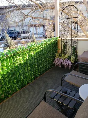 a green wall with plants and tables and flowers at Entire 1 BR Condo- Near Anschutz, UC Health, DIA- In-Unit Washer Dryer- Seasonal Discounts! in Aurora