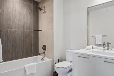 a white bathroom with a toilet and a sink at Polished Stayscape | Espadin LoHi in Denver