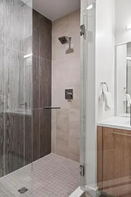 a shower with a glass door in a bathroom at Polished Stayscape | Espadin LoHi in Denver