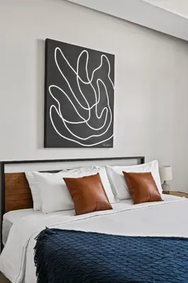 a bedroom with a large bed with brown and white pillows at Polished Stayscape | Espadin LoHi in Denver