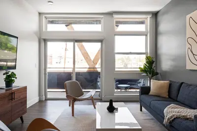 a living room with a couch and a table at Polished Stayscape | Espadin LoHi in Denver