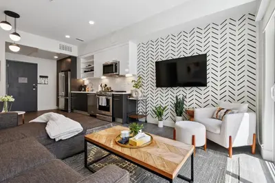 a living room with a couch and a table at Sky’s Edge Suite | Espadin LoHi in Denver