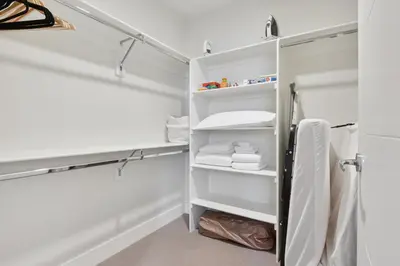 a white closet with white shelves and towels at Sky’s Edge Suite | Espadin LoHi in Denver